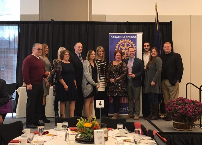 Group photo of Rotary scholarship foundation employees and board members posing together, smiling<br />
